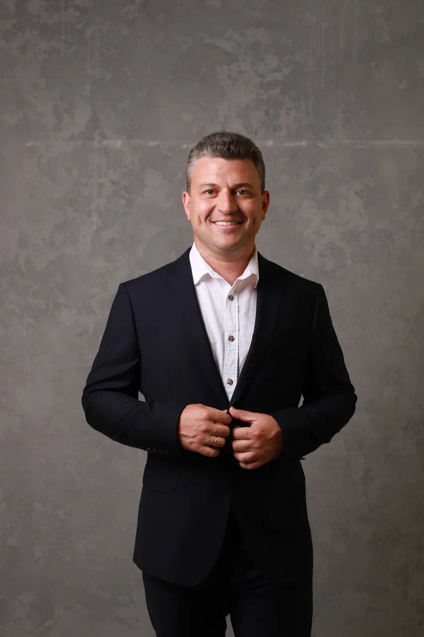 Мужчина в деловом костюме на сером фоне, портрет городского эксперта