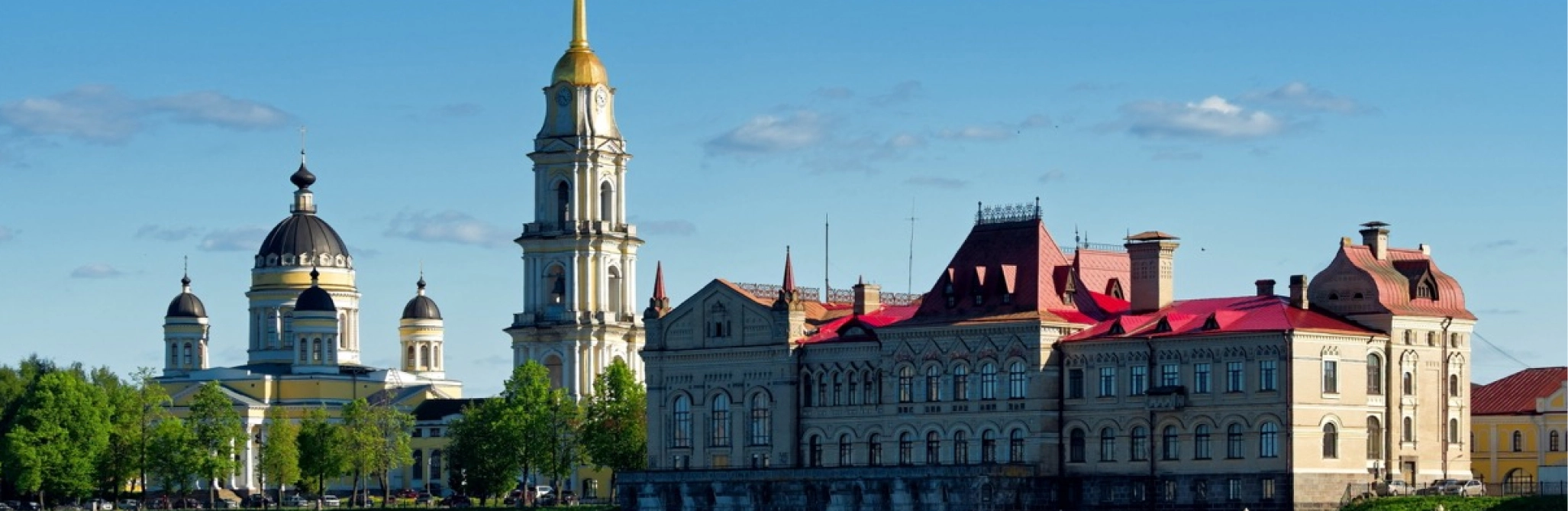 Архитектурный ансамбль с православным собором, высокой колокольней и историческим зданием с красной крышей.