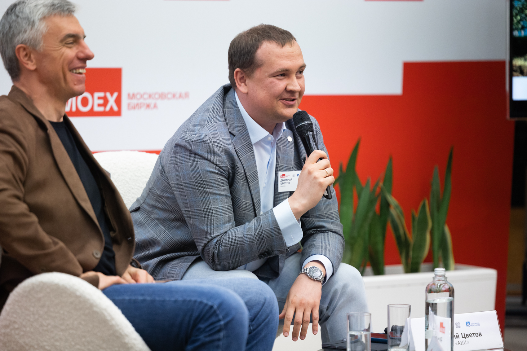 Мужчина говорит в микрофон на конференции Московской биржи.