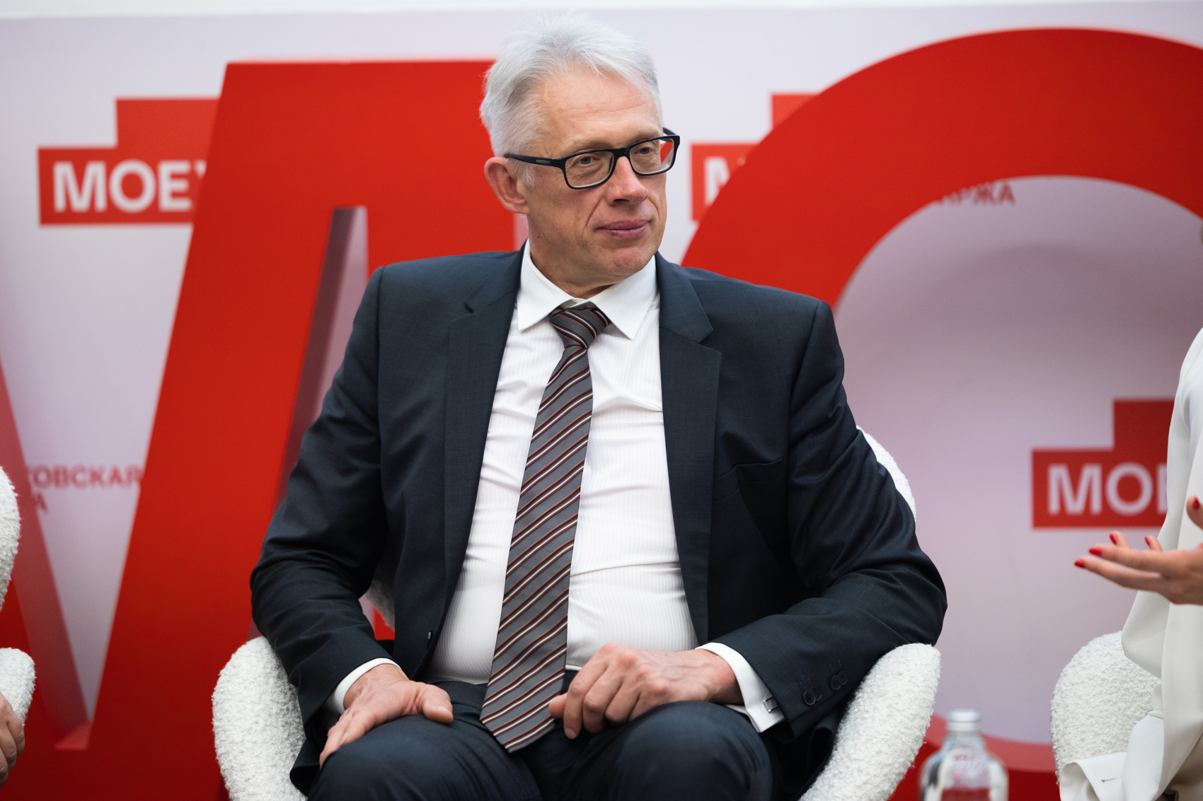 Мужчина в деловом костюме на конференции Московской биржи.