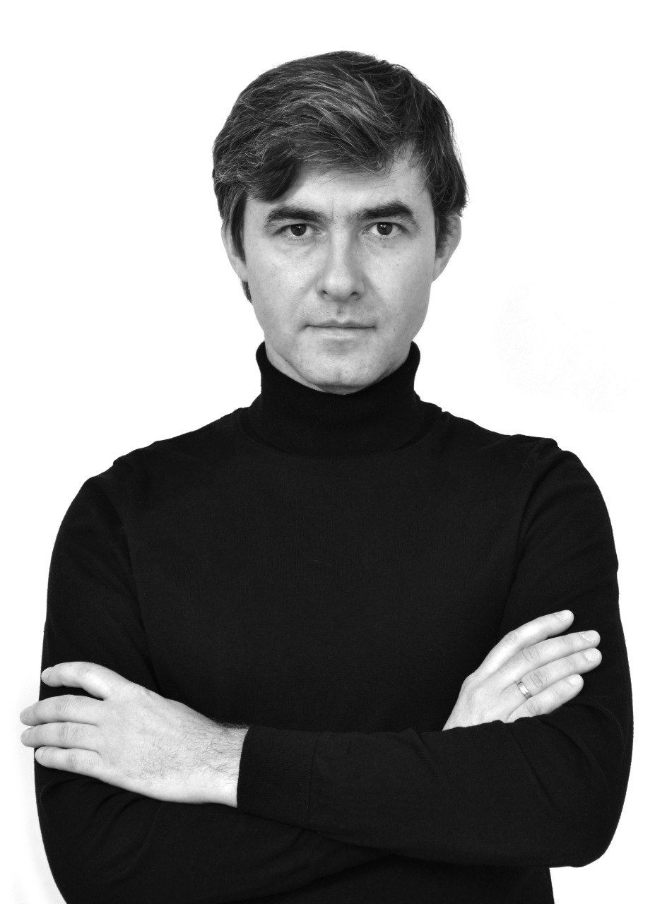 Портрет мужчины в черной водолазке на белом фоне, представитель архитектурного сообщества