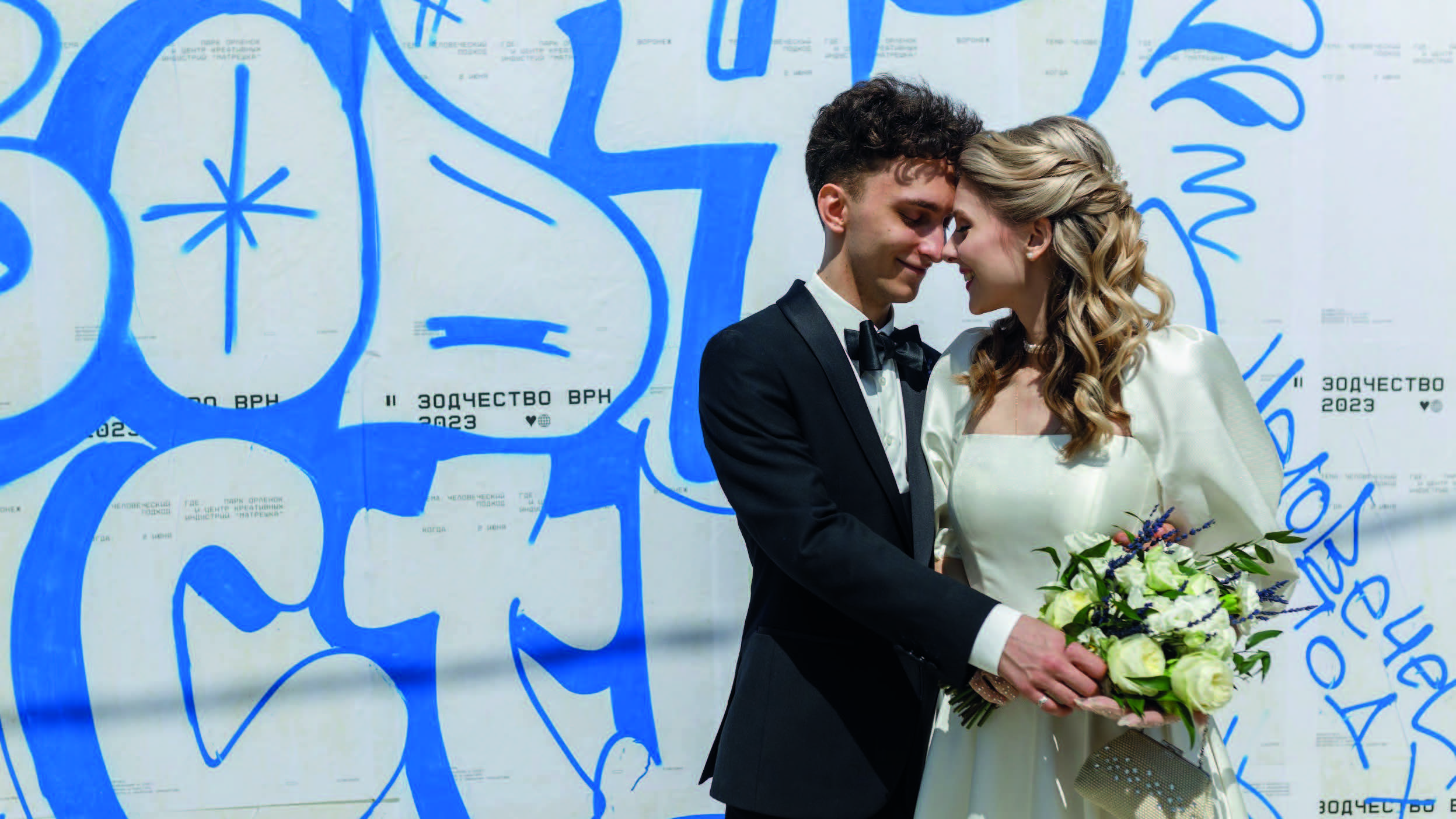Молодожёны позируют на фоне граффити Зодчество ВРН 2023